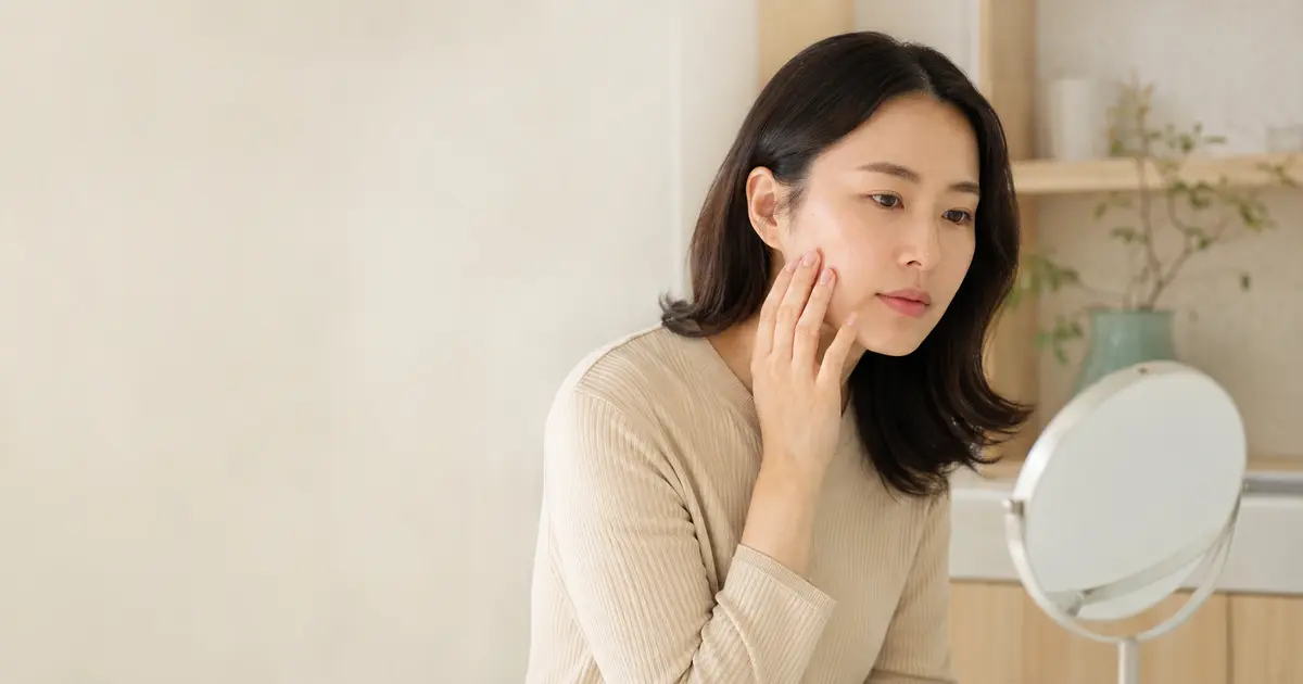 피부 상태를 거울로 세심하게 확인하는 환자